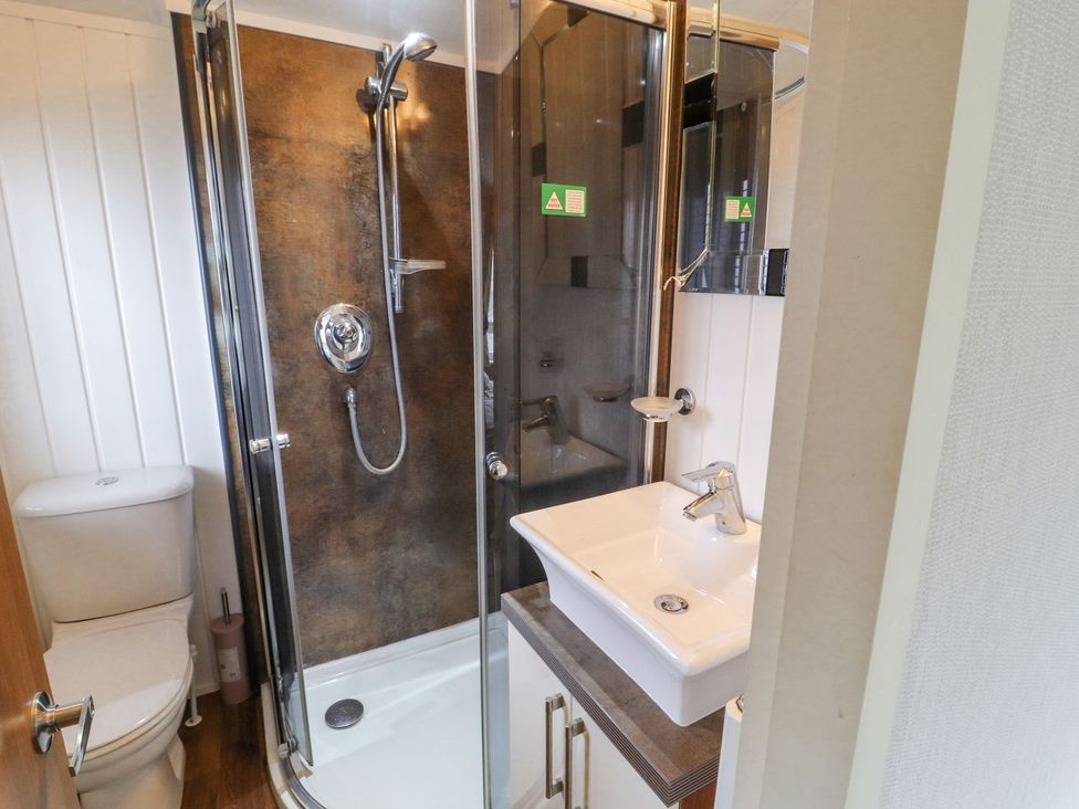 A bathroom with a shower, toilet, and sink at No 8 Hillcote Lodge in Cockermouth