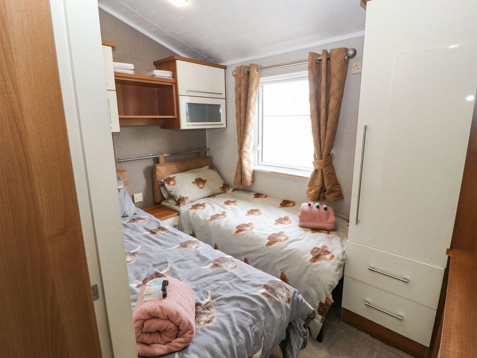 A bedroom with two beds and a wardrobe at No 8 Hillcote Lodge Cockermouth