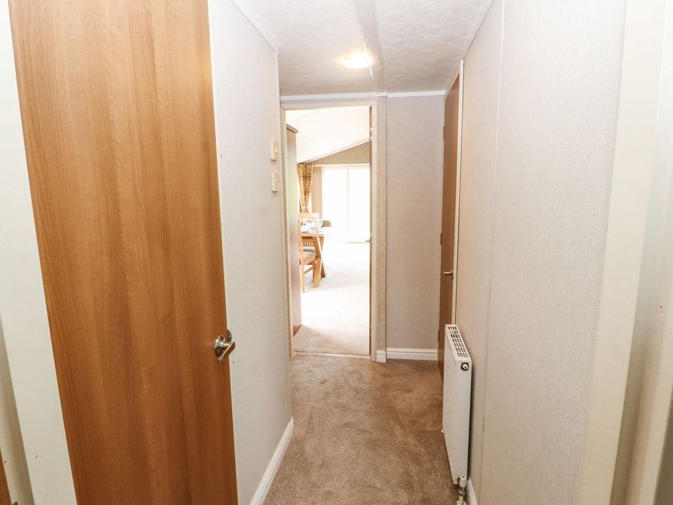 A hallway with a door and a radiator at No 8 Hillcote Lodge Cockermouth