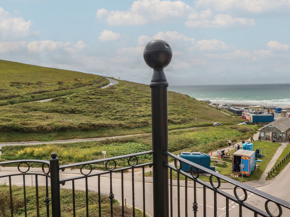 A view from a balcony overlooking a hill and the sea at Beachcombers Apt 11