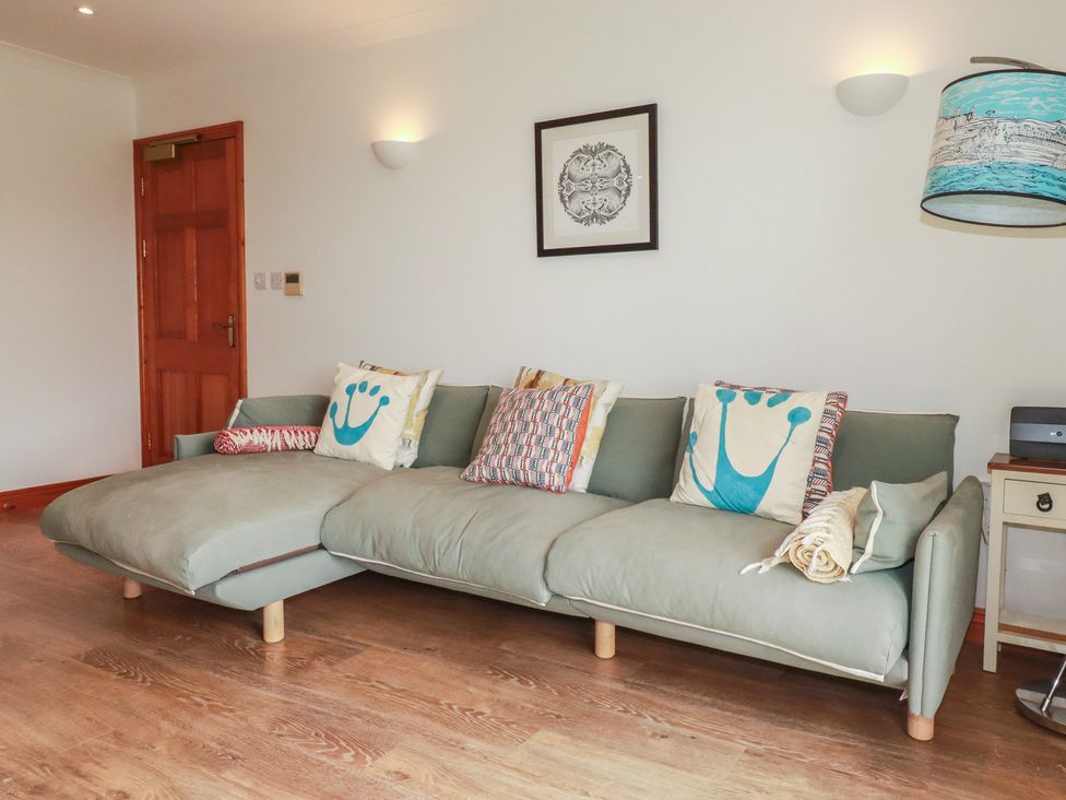 A living room with a sofa and cushions at Beachcombers Apt 11