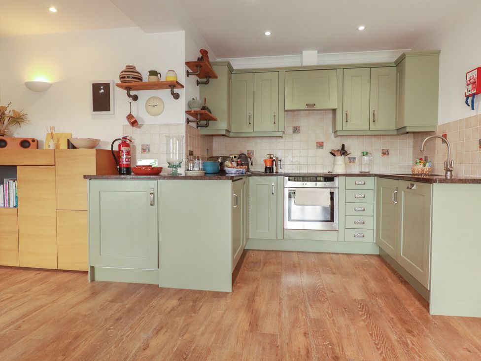 A kitchen with cabinets and stove at Beachcombers Apt 11