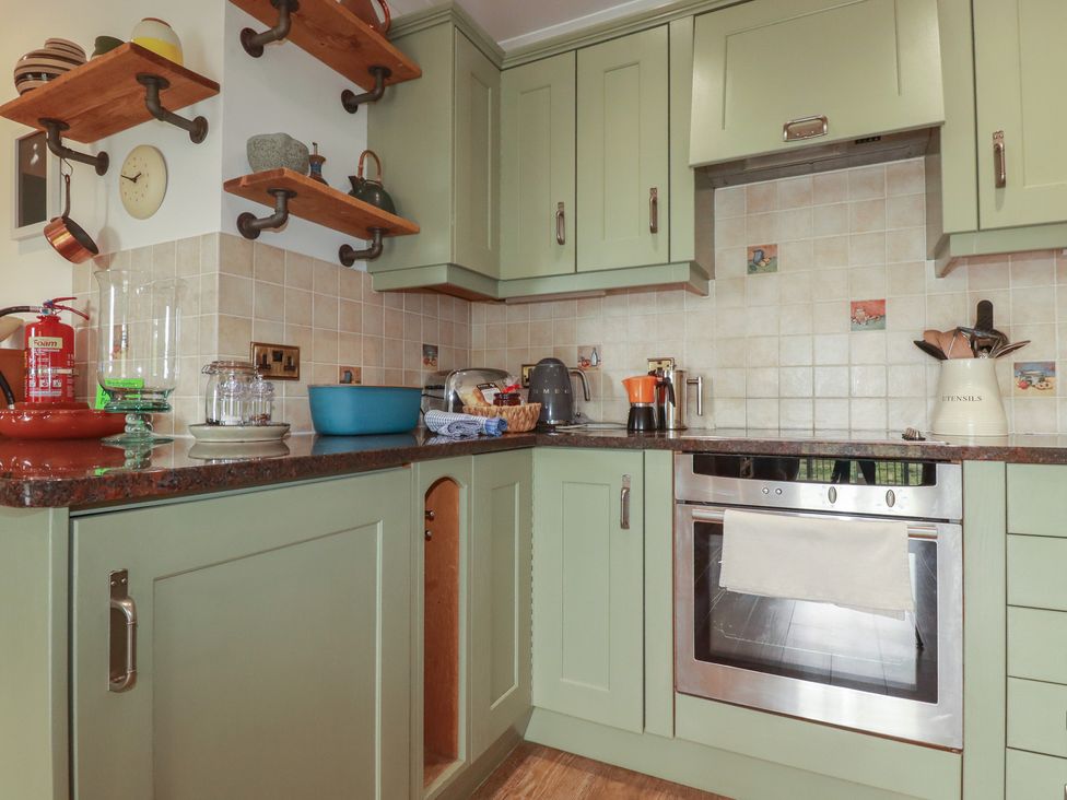 A kitchen with cabinets and appliances at Beachcombers Apt 11