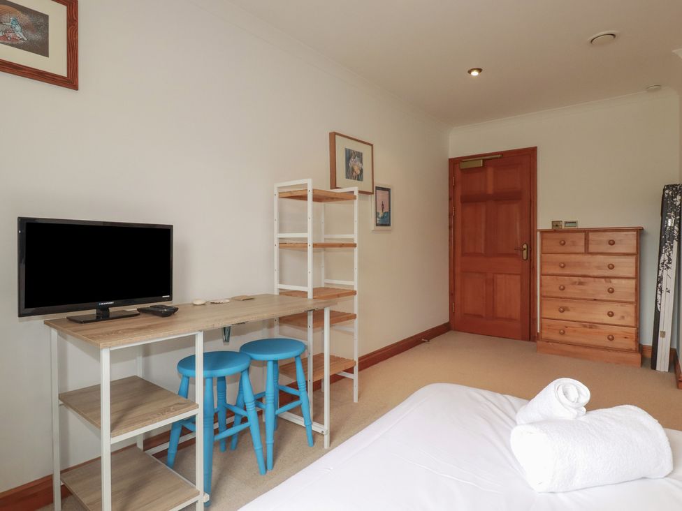 A bedroom with a television and desk at Beachcombers Apt 11 