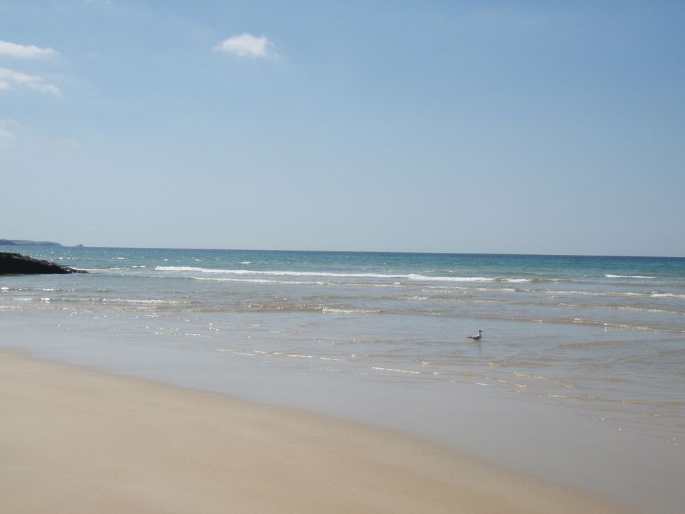 A beach with sand and waves at Beachcombers Apt 11 Watergate Bay near Newquay