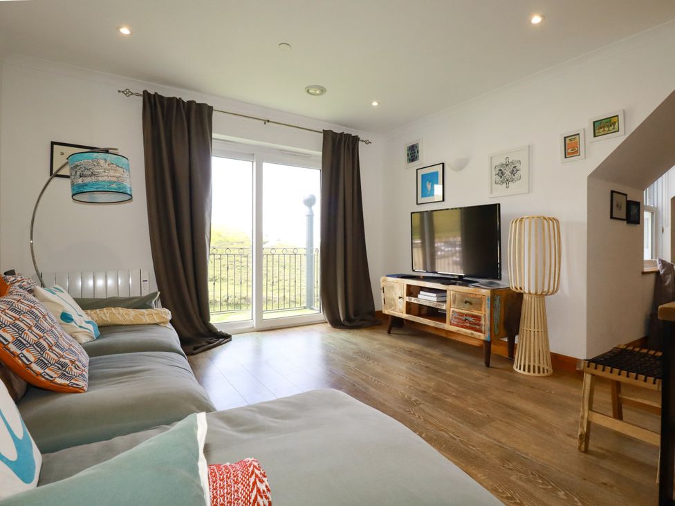 A living room with a television on a TV stand at Lowenna Watergate Bay near Newquay