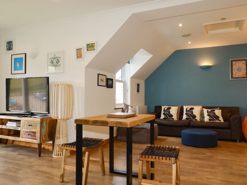 A living room with a sofa and television at Lowenna Watergate Bay near Newquay