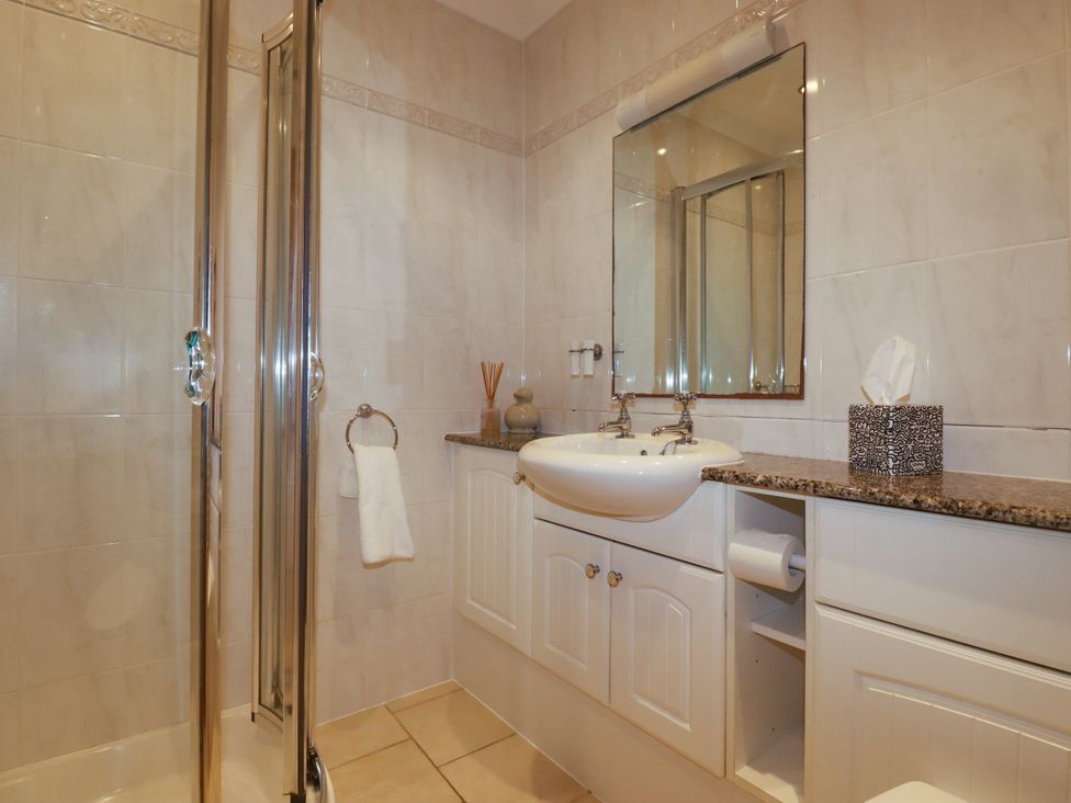 A bathroom with a shower and sink at Lowenna Watergate Bay near Newquay