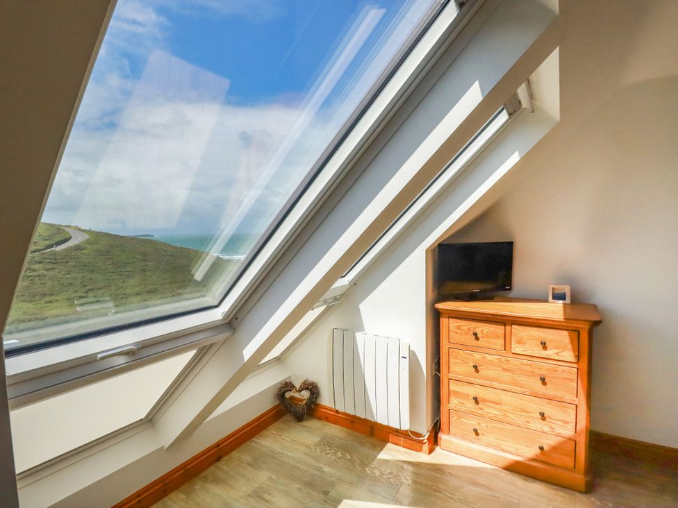 A bedroom with a window and a dresser at Lowenna Watergate Bay near Newquay