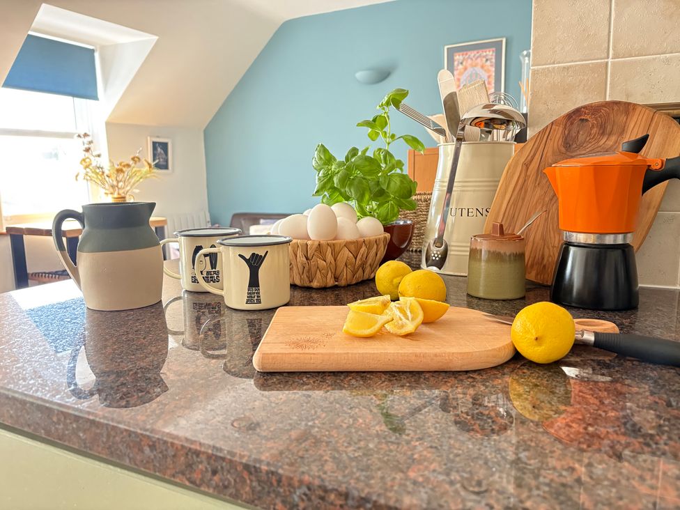 A kitchen countertop with mugs, eggs, and a coffee maker at Lowenna in Watergate Bay near Newquay