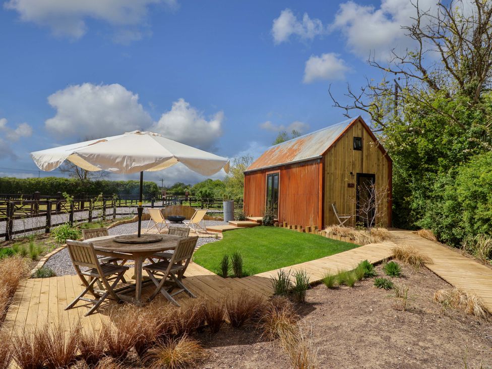 An outdoor area with a table and chairs at Shades Farm Shepherds Hut (Sleeps 4) Circenester