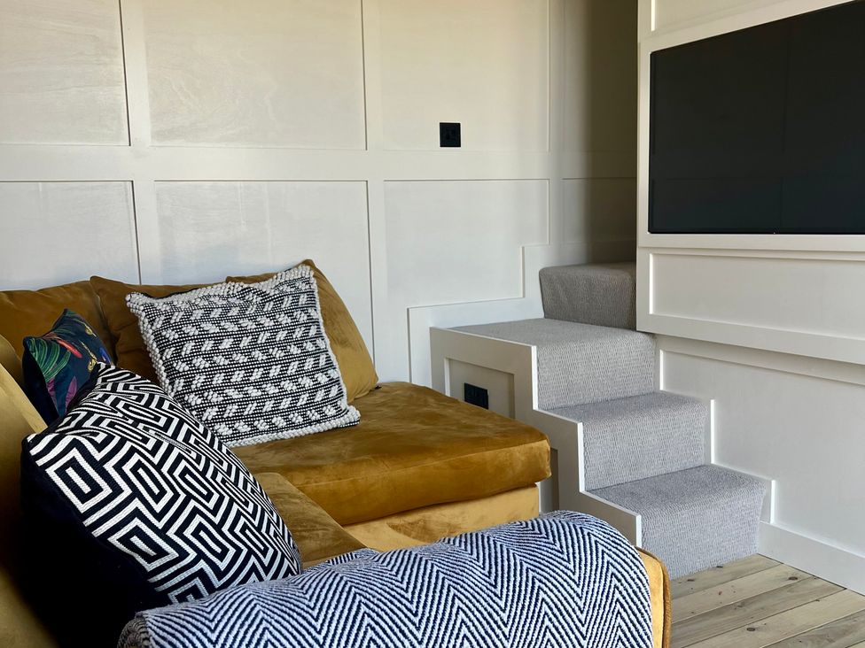 A living room with a couch and television at Rustwood Manor in Minety