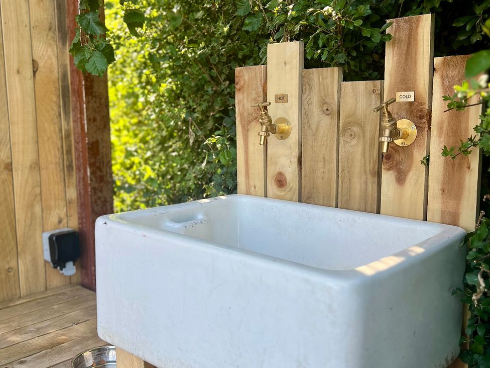 A sink with hot and cold taps at Rustwood Manor in Minety