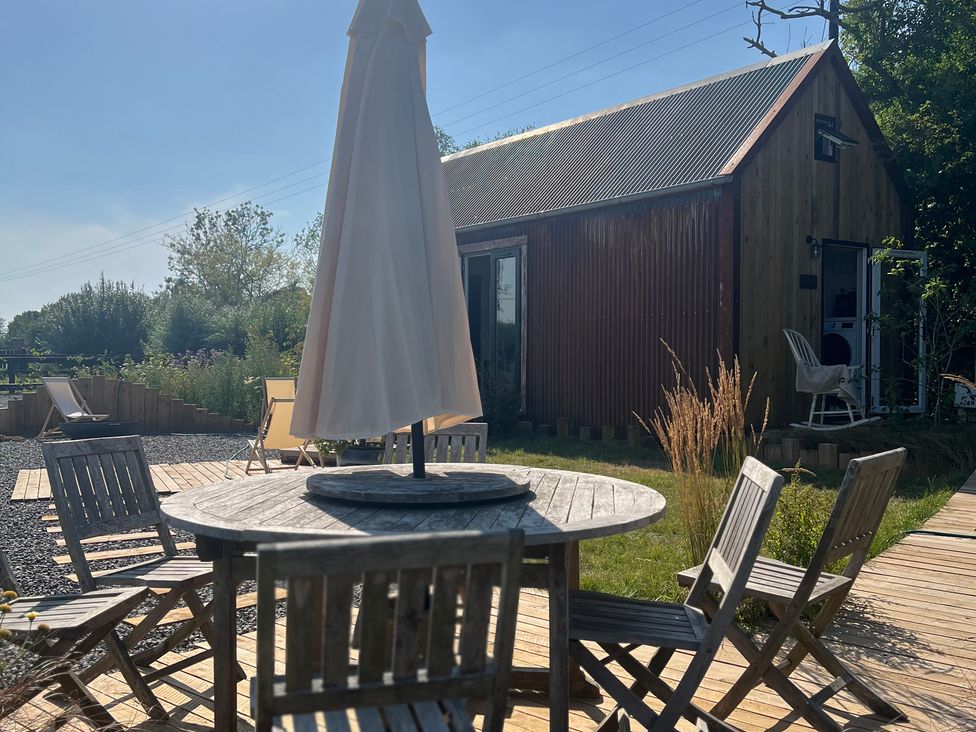 An outdoor setting with a table and chairs at Rustwood Manor in Minety