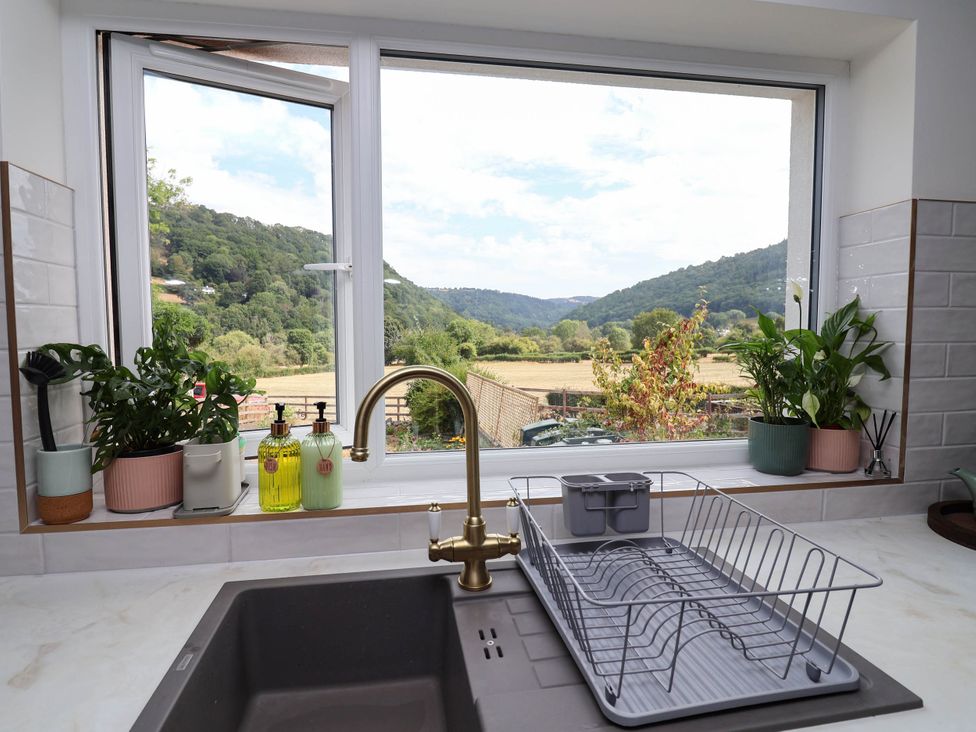 A kitchen with a sink and window overlooking hills at Araelfa in Llangollen