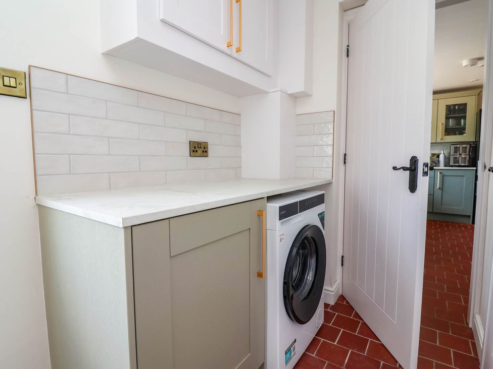 A laundry room with a washing machine and countertop at Araelfa in Llangollen