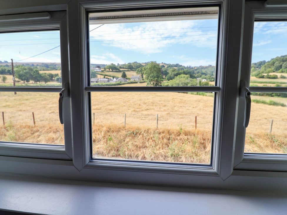 A view from a window showing a field and hills at Araelfa in Llangollen