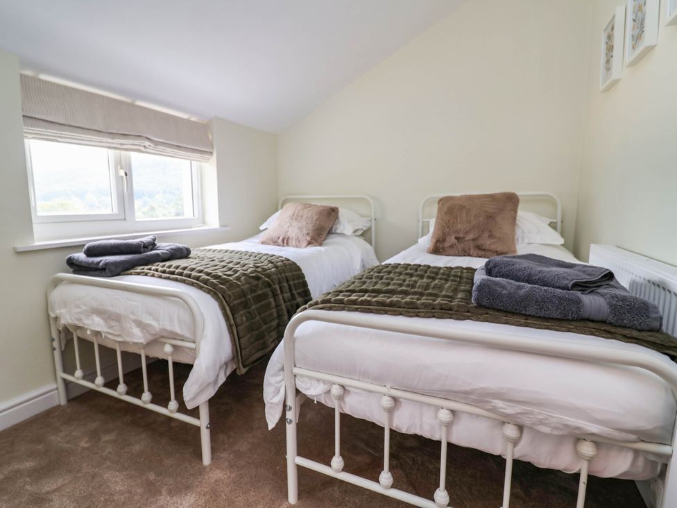 A bedroom with two beds and a window at Araelfa in Llangollen