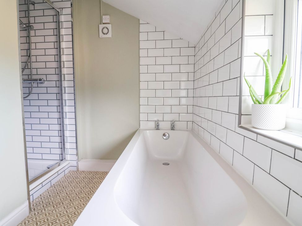A bathroom with a bathtub and a shower at Araelfa in Llangollen