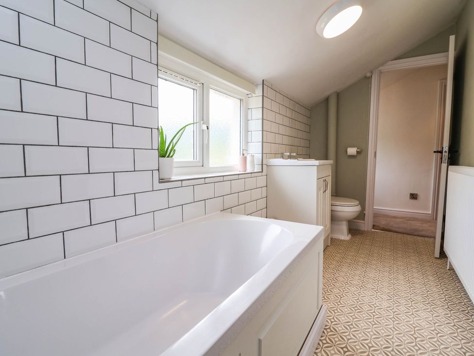 A bathroom with a bathtub, sink, and toilet at Araelfa in Llangollen