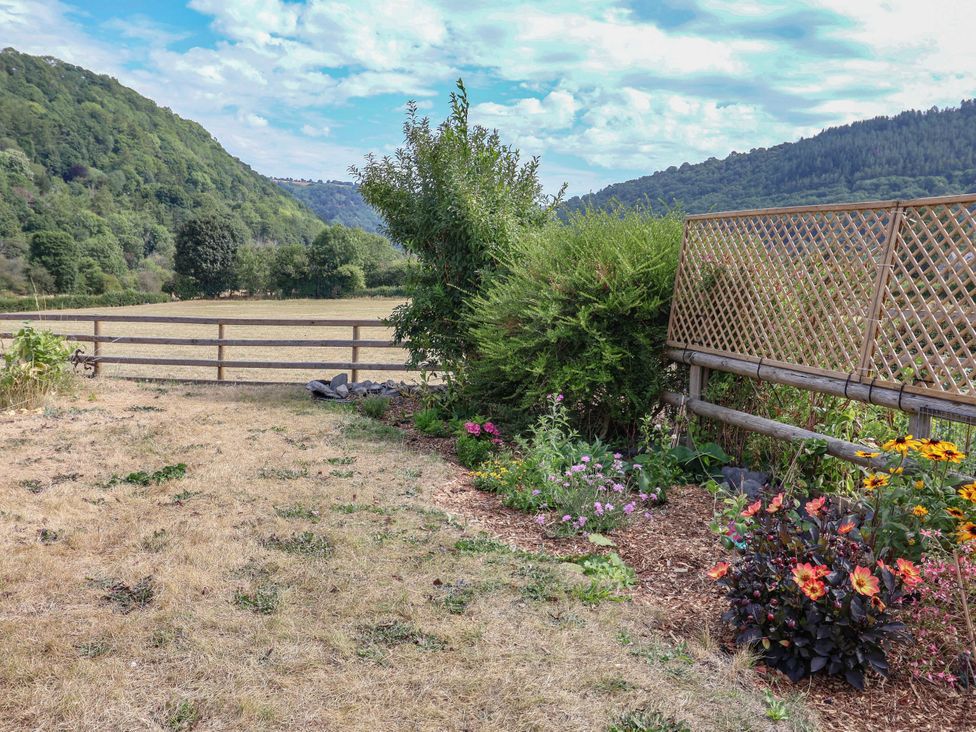 A garden with flowers and a wooden fence at Araelfa in Llangollen