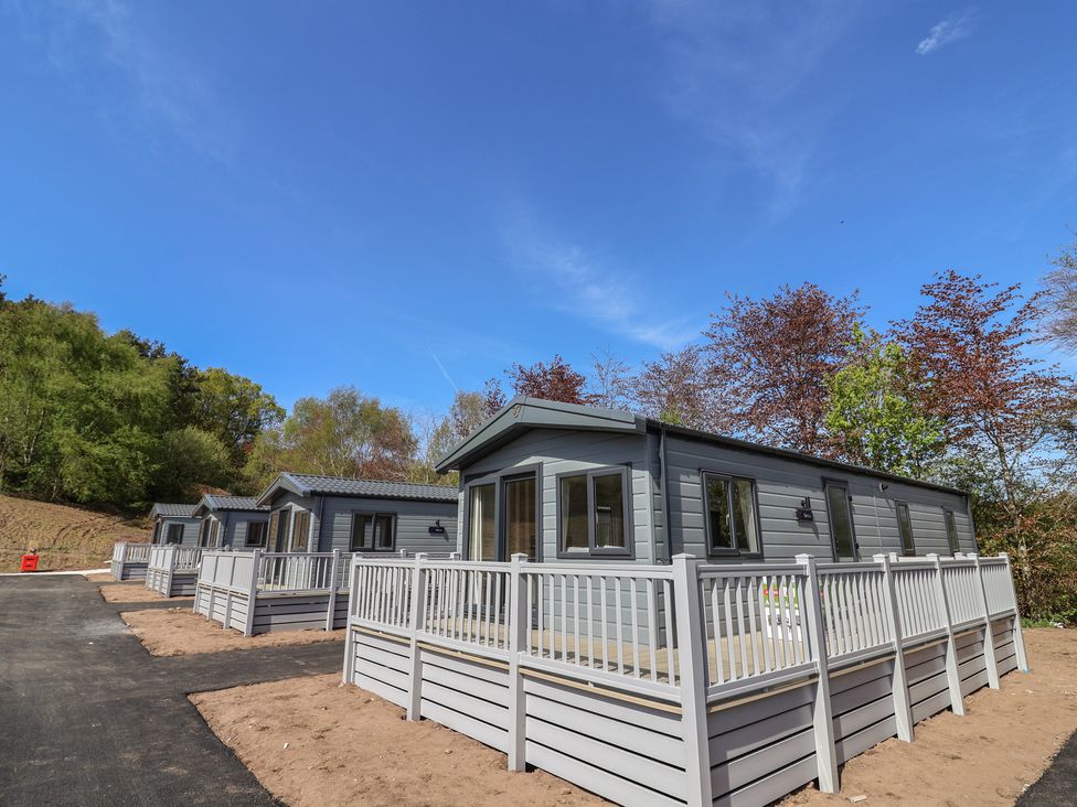 Three cabins with decks and railings in a natural setting at No.20 - The Oaks in Delamere