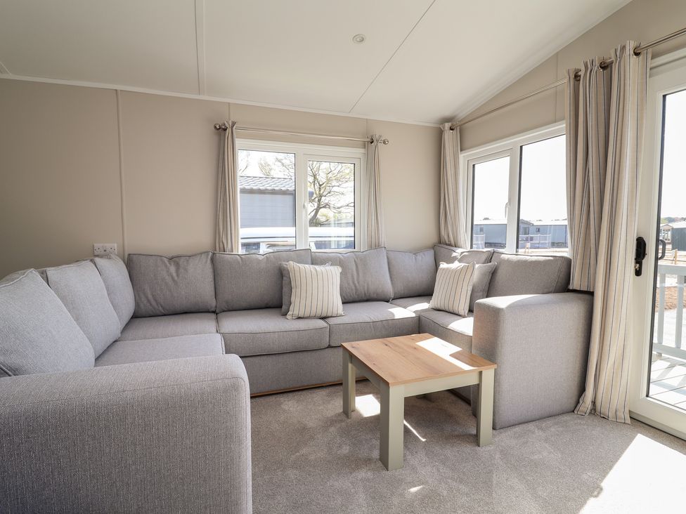 A living room with a sofa, armchair, and coffee table at No.20 - The Oaks in Delamere