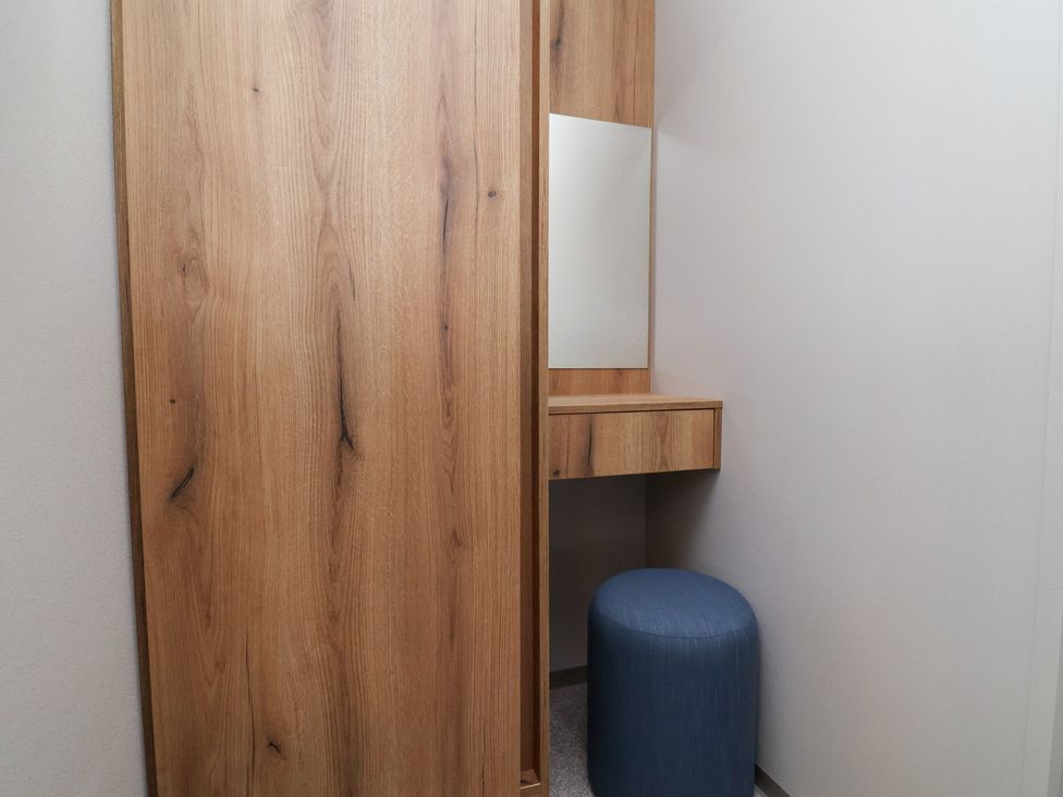 A dressing area with a mirror and stool at No.20 - The Oaks, Delamere