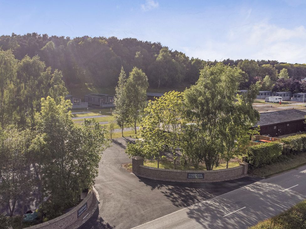 A view of Fishpool Holiday Park with caravans and trees in Delamere