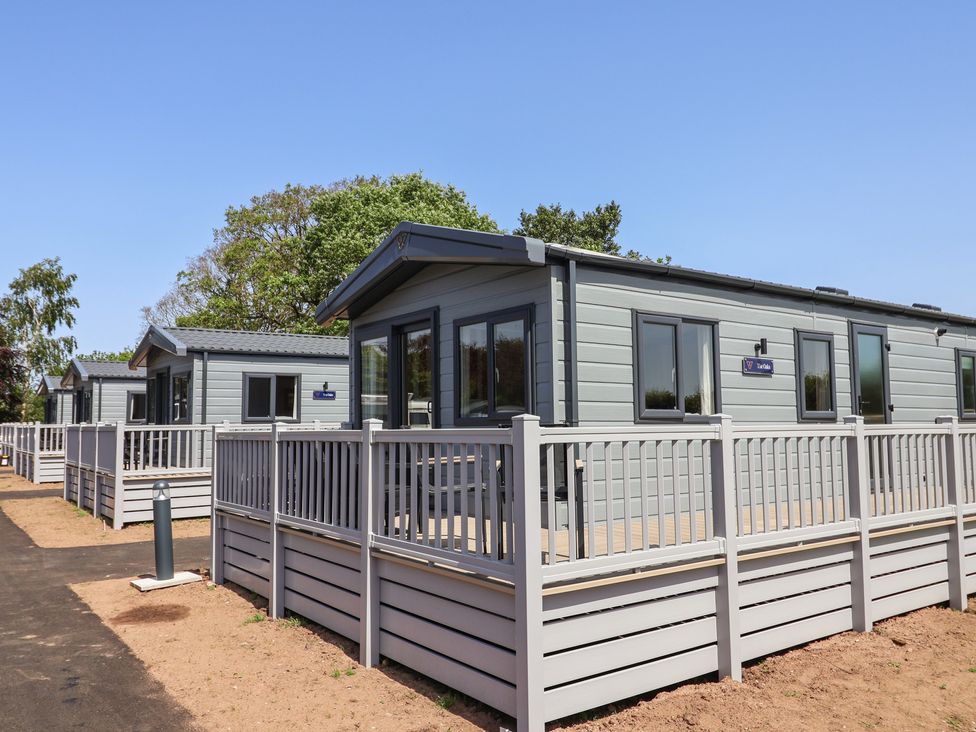 A row of cabins with a wooden fence at The Oaks 2 Bedrooms in Delamere