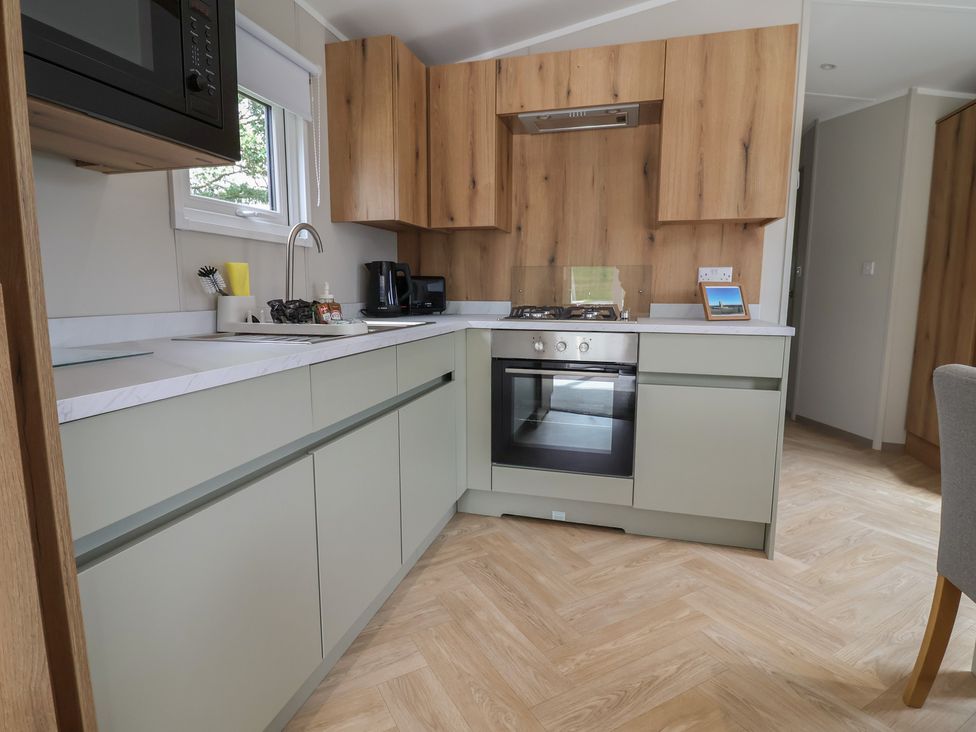 A kitchen with cabinets and appliances at The Oaks 2 Bedrooms Delamere