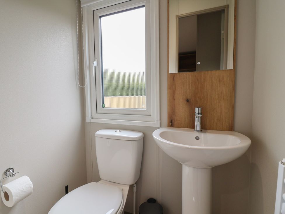 A bathroom with a toilet and sink at The Oaks 2 Bedrooms in Delamere