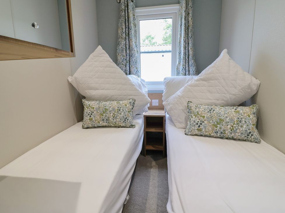 A bedroom with two beds and a window at The Oaks 2 Bedrooms in Delamere