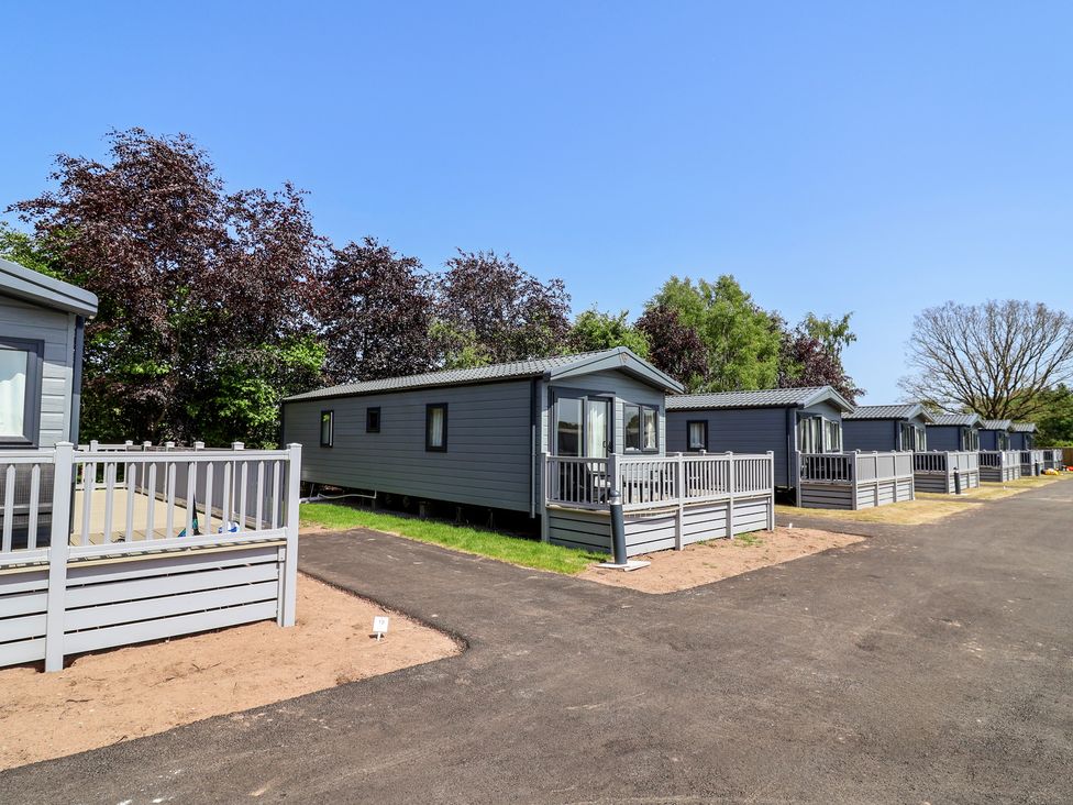 A row of static caravans with decking at The Oaks 2 Bedrooms in Delamere