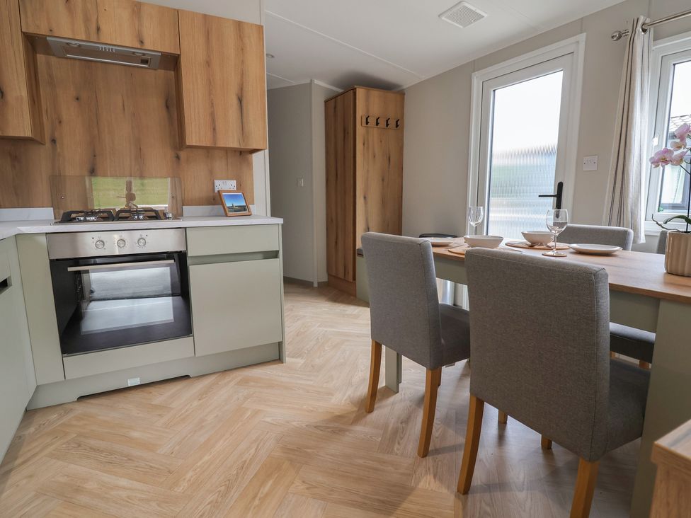 A kitchen with an oven and dining area at The Oaks 2 Bedrooms Delamere