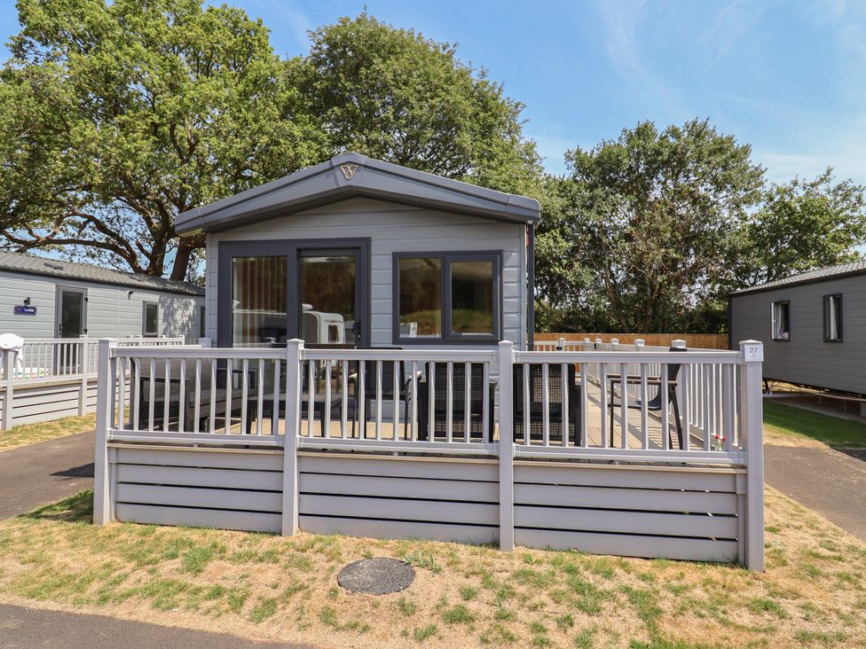 An outdoor view of a cabin with decking and railing at The Oaks 2 Bedrooms Delamere
