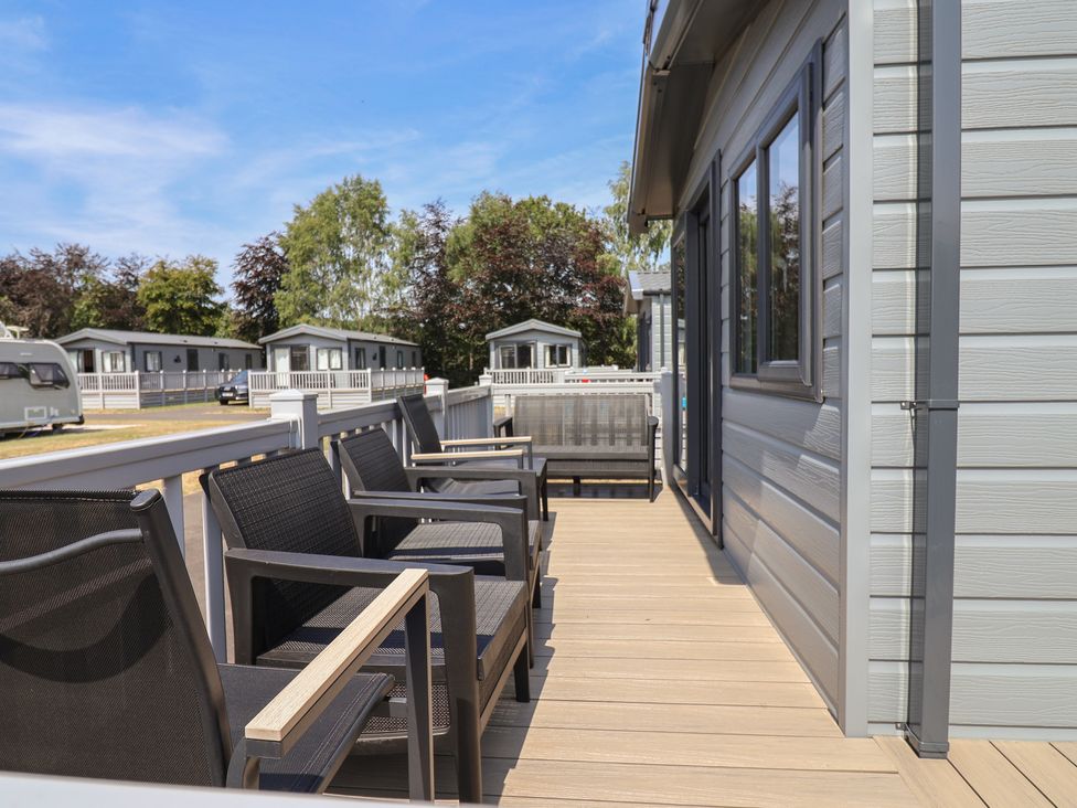 An outdoor area with seating and a view of cabins at The Oaks 2 Bedrooms Delamere