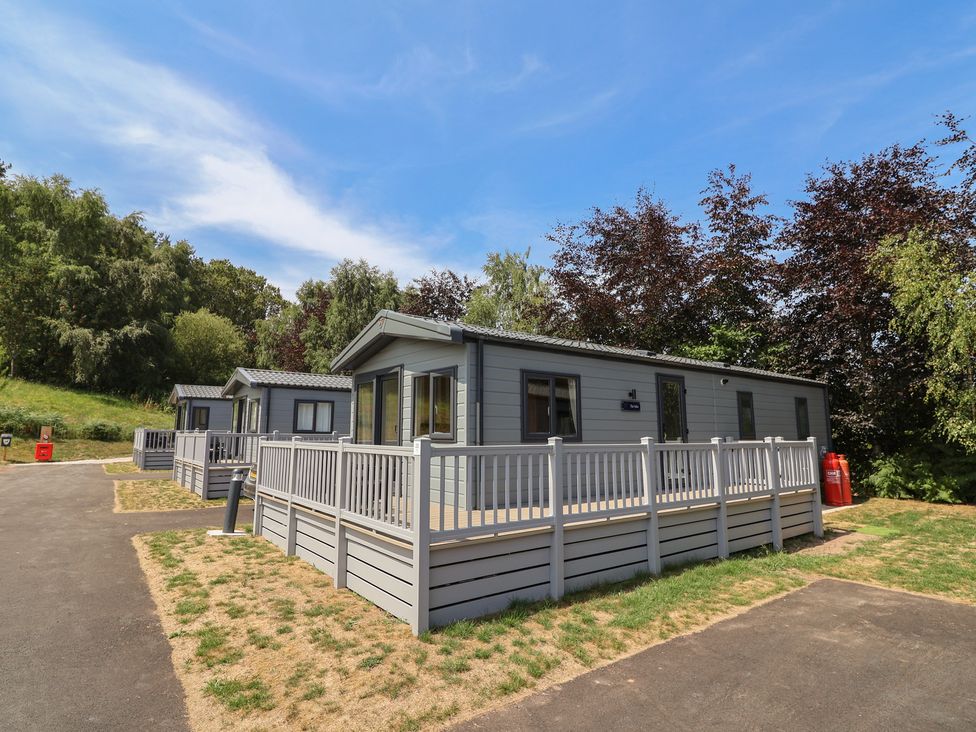 Cabins with porches and walkways at The Oaks 2 Bedrooms in Delamere