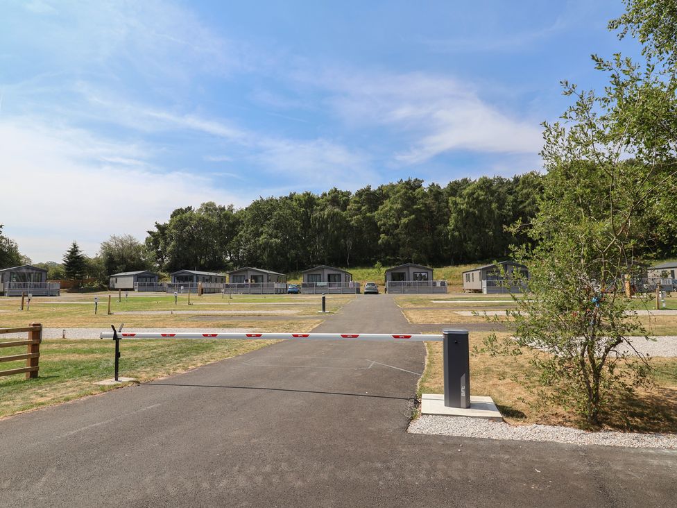 A view of mobile homes in a park area with an access gate at The Oaks 2 Bedrooms Delamere