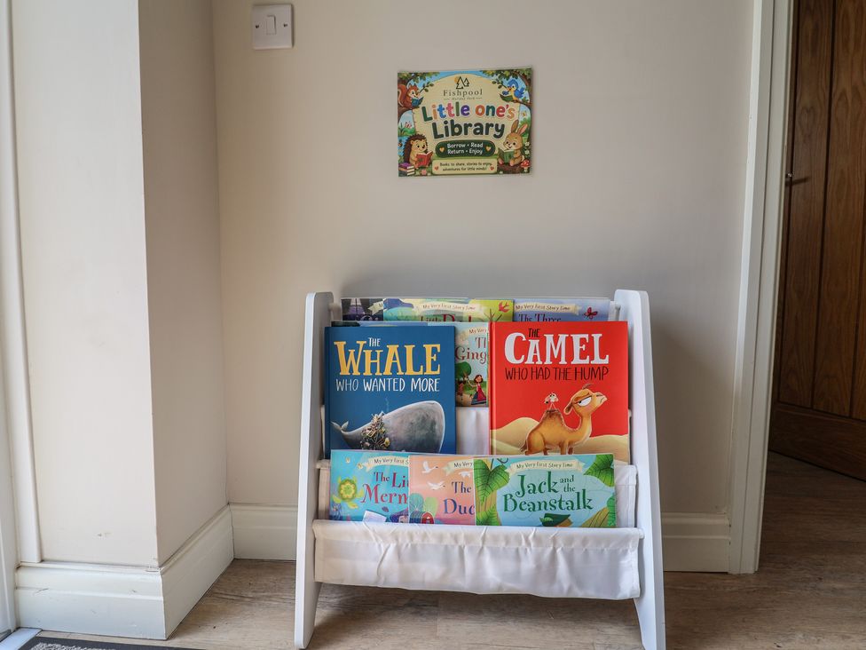 A bookshelf with children's books in a reading nook at The Oaks 2 Bedrooms in Delamere