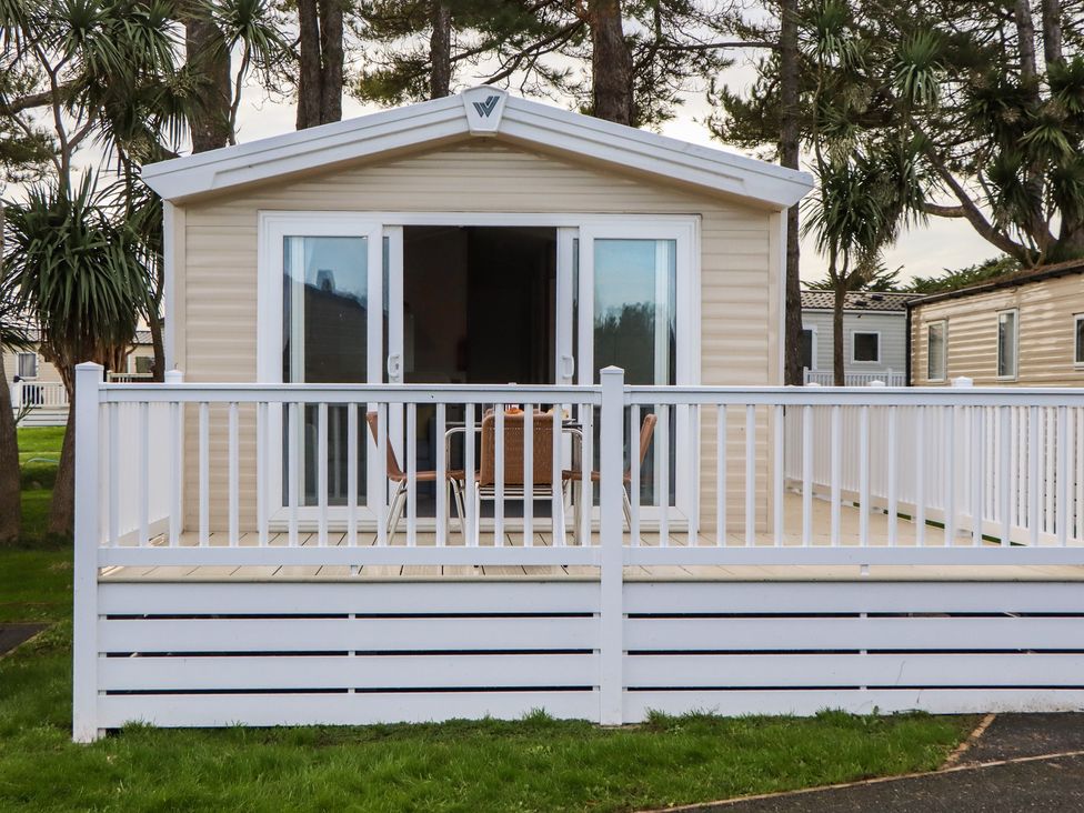 A holiday home with a deck and chairs at Caravan A10 at Landscove Holiday Park Brixham