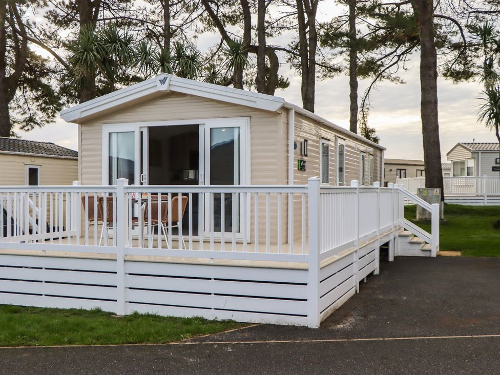 A caravan with deck and seating area at Caravan A10 at Landscove Holiday Park Brixham