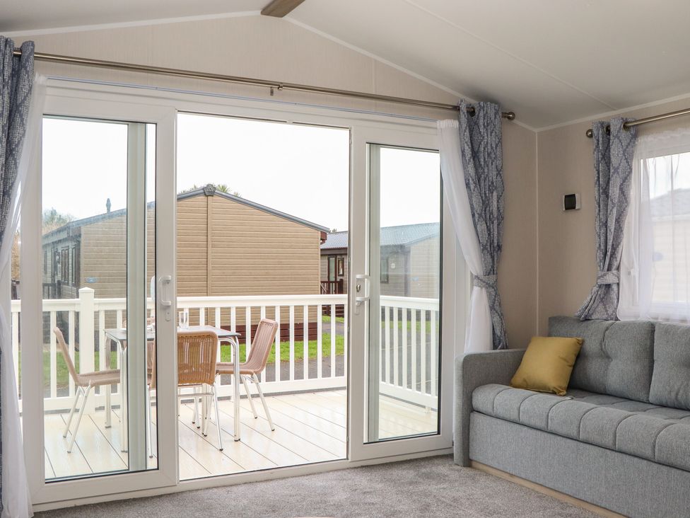 A living room with sliding doors to a deck at Caravan A10 at Landscove Holiday Park Brixham