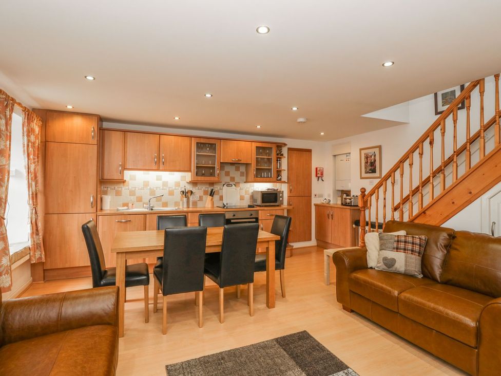 A kitchen with dining area and staircase at Flour Loft in Anstruther