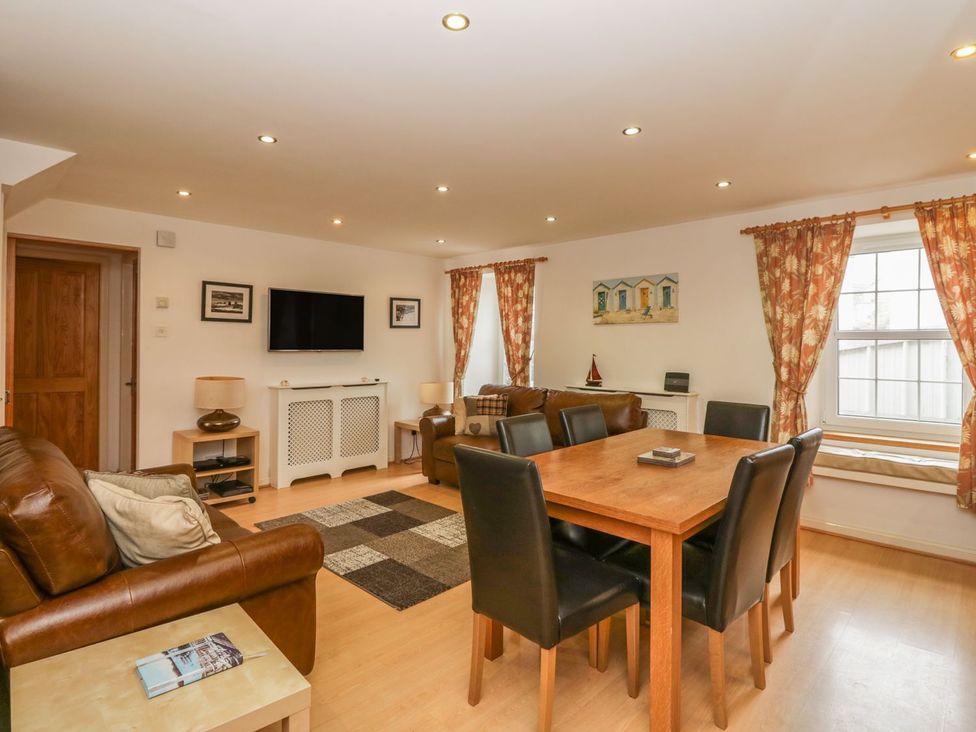 A living room with a table and chairs and a television at Flour Loft in Anstruther