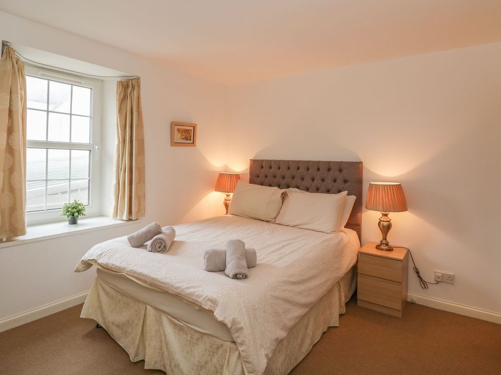 A bedroom with a bed and bedside tables at Flour Loft Anstruther