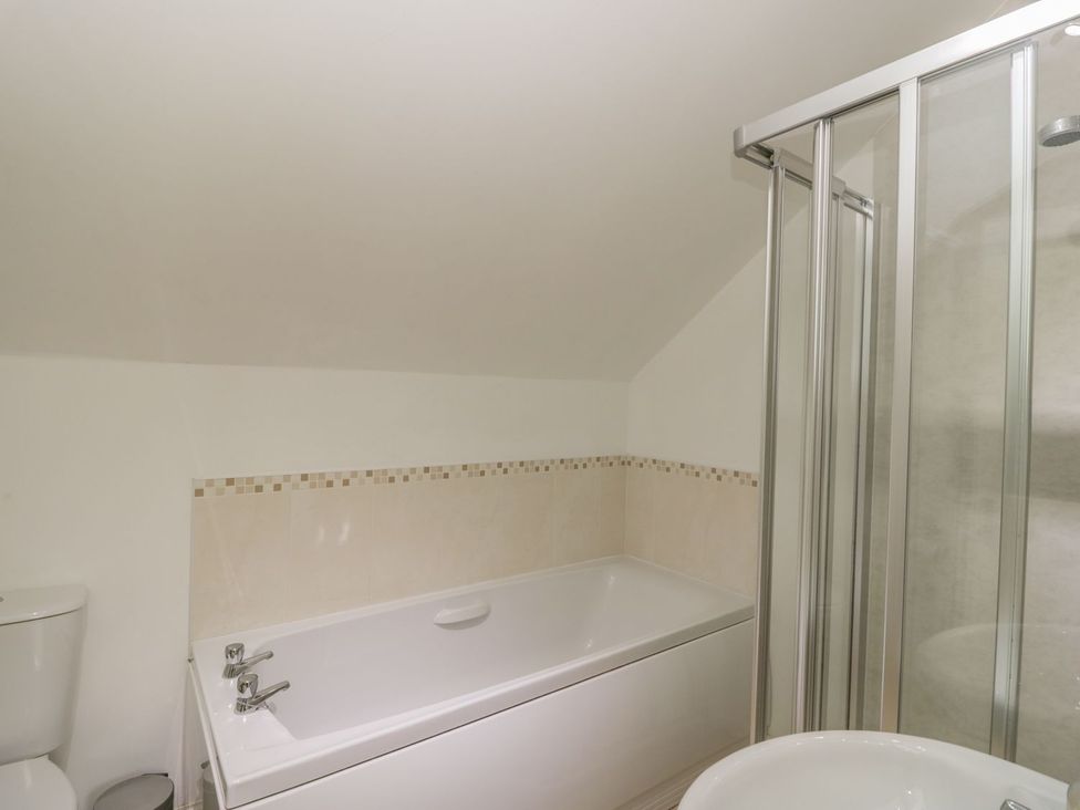 A bathroom featuring a bathtub, shower enclosure, toilet, and sink at Flour Loft Anstruther