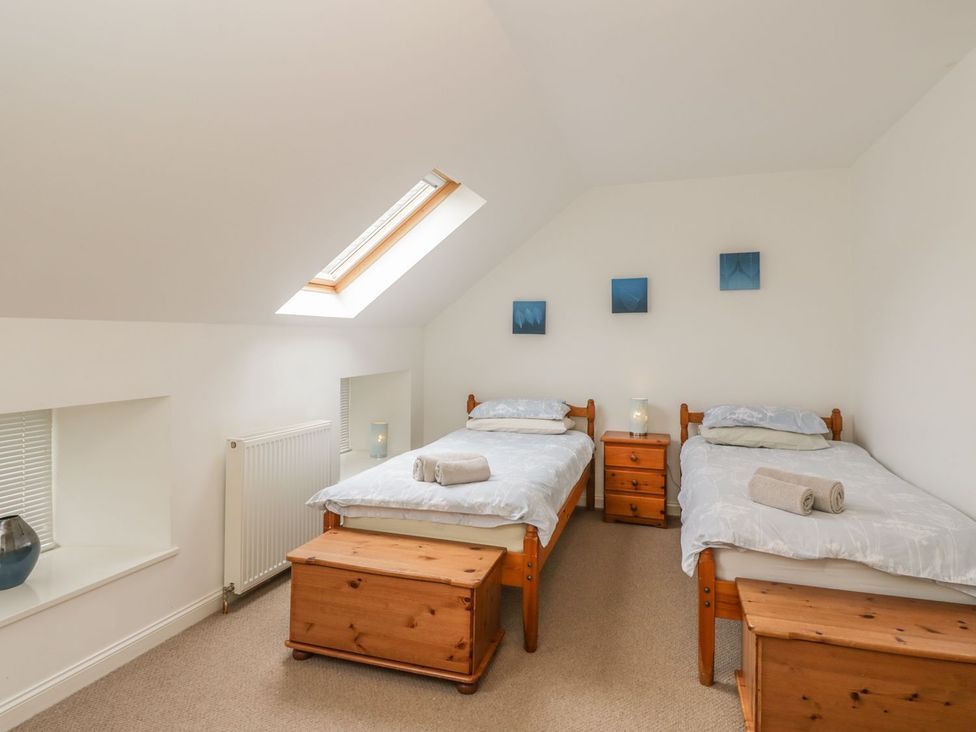 A bedroom with two single beds and wooden furniture at Flour Loft in Anstruther