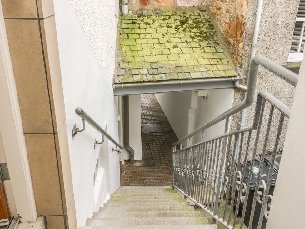 Stairs leading down to a pavement with a rubbish bin at Flour Loft Anstruther