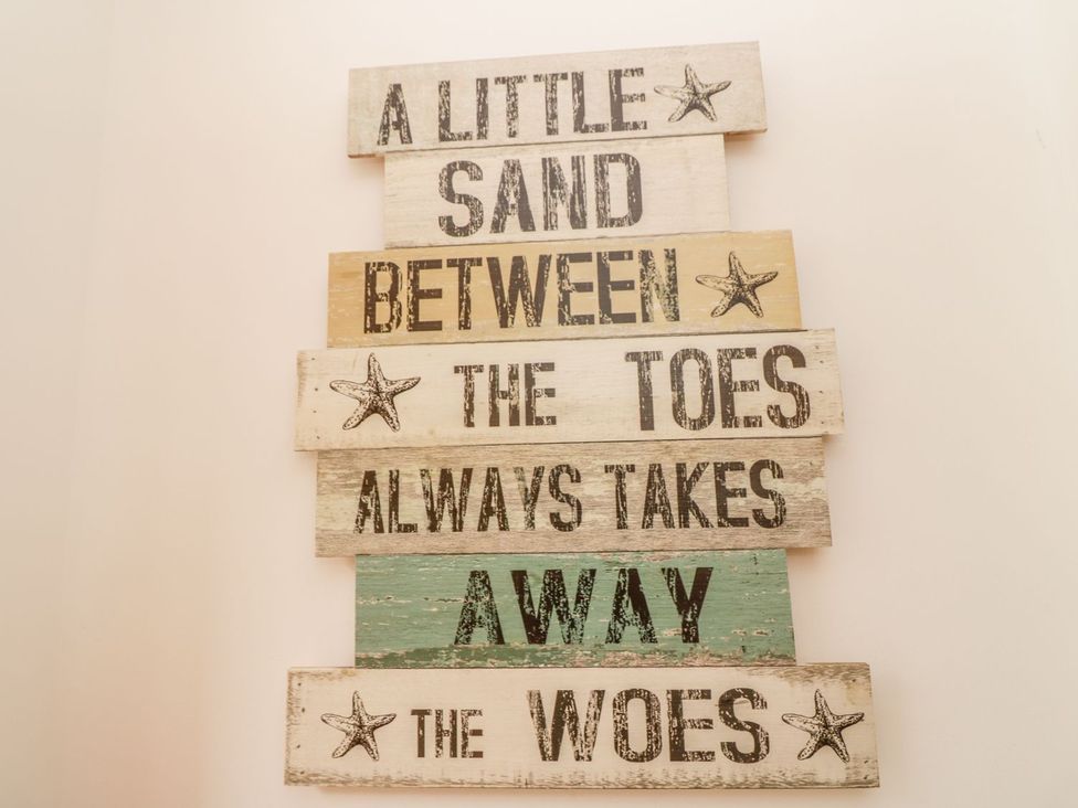 A decorative sign with text and starfish at Flour Loft in Anstruther